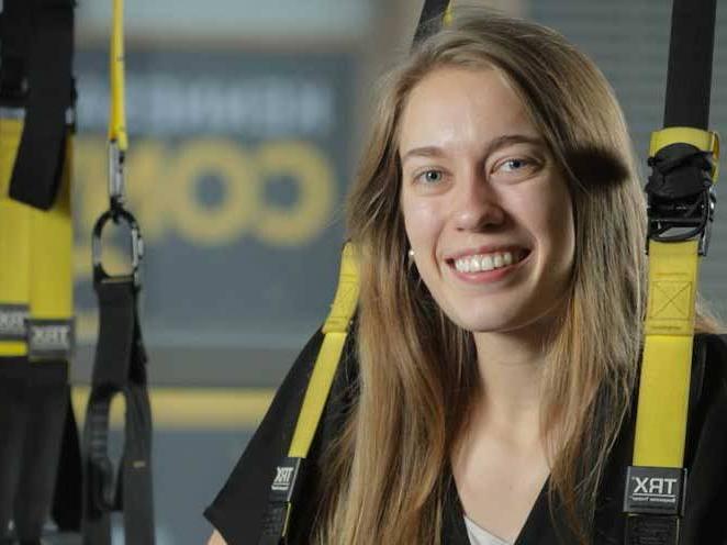 Woman is strapped into safety gear