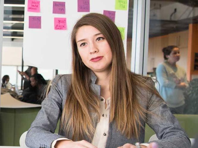 Student dressed business like sitting down smiling for a picture