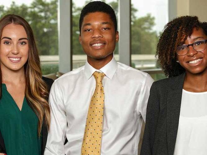 Group of business students standing together smiling for a picture