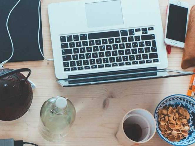 Top view of a laptop, snacks, and coffee