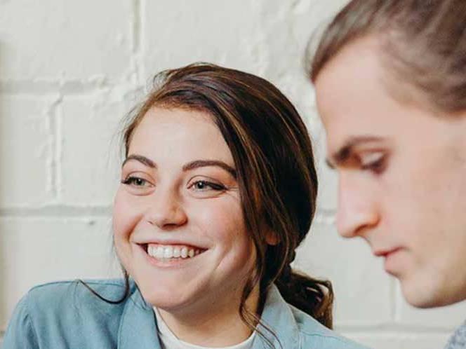 Man is focusing while the woman is smiling for picture