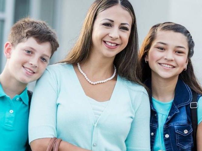 Woman with two younger children smiling for a picture