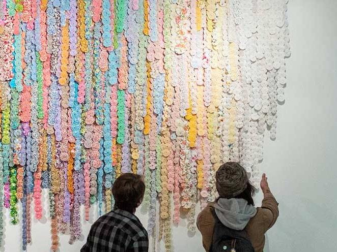 Two men looking at colorful art on the wall